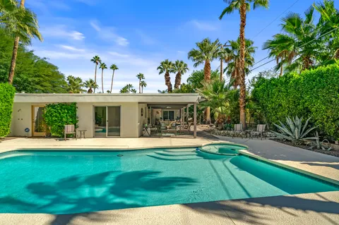 a dining area with a table chairs and a kitchen view