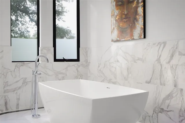 a white bath tub sitting next to a shower
