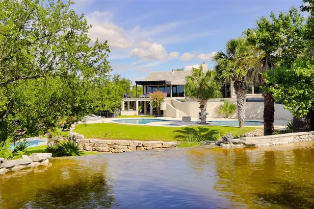 a view of a fountain in front of a house with a yard and a fountain