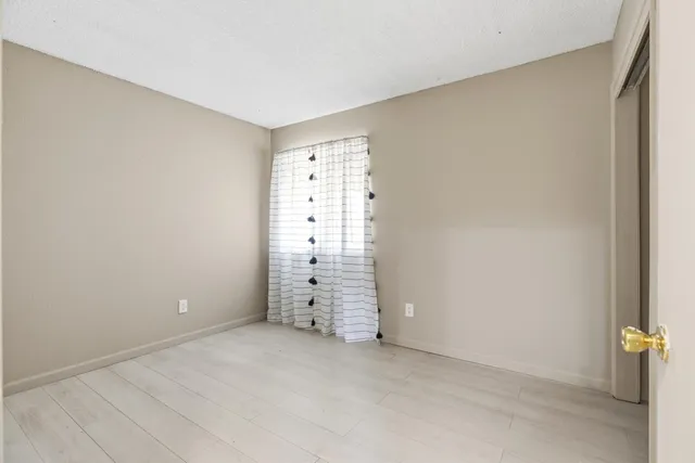 an empty room with cabinet and mirrors