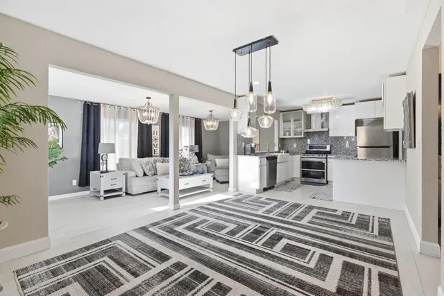 a living room with lots of furniture and kitchen view