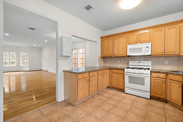a kitchen with stainless steel appliances granite countertop a stove top oven sink and cabinets