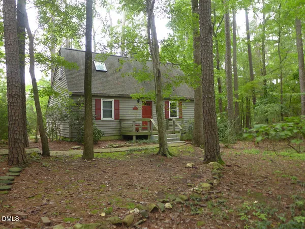 a view of a house with a yard and tree