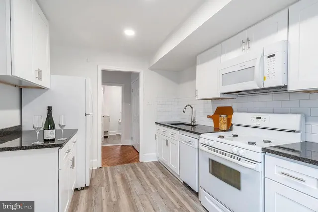 a kitchen with a stove and white cabinets