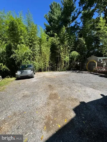 a view of backyard with a car parked on the road