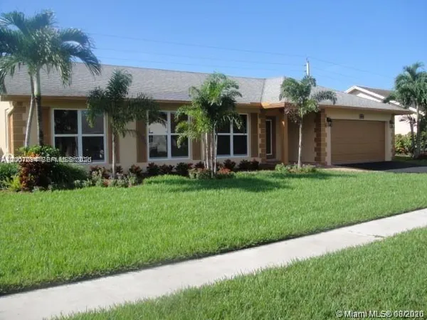 a front view of a house with a garden and plants