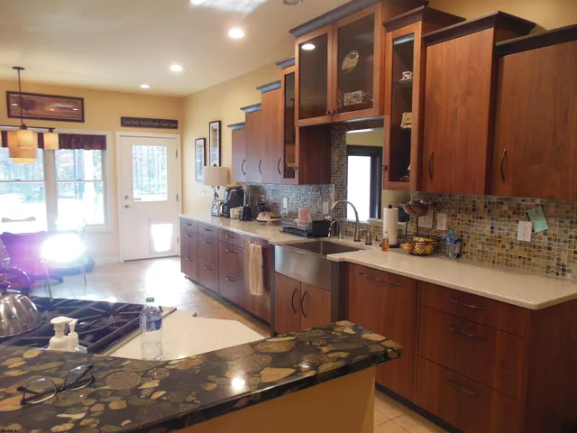 a view of a kitchen with granite countertop a sink stainless steel appliances and cabinets