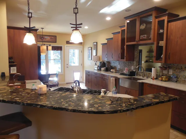 a kitchen with stainless steel appliances kitchen island granite countertop a refrigerator and a stove