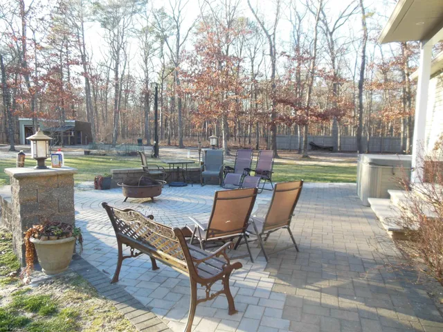 a view of backyard with wooden fence and large trees