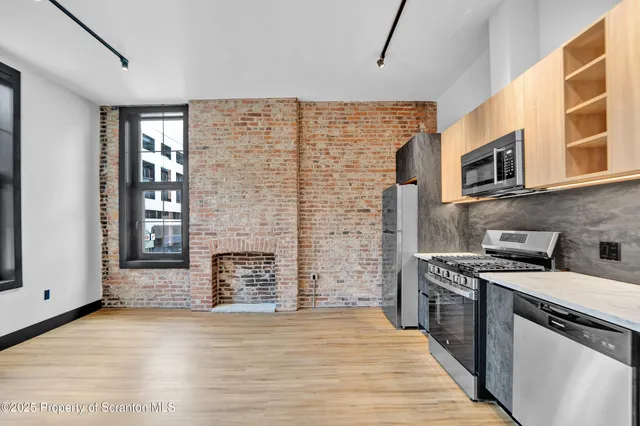 a kitchen with stainless steel appliances a stove top oven a sink and a refrigerator