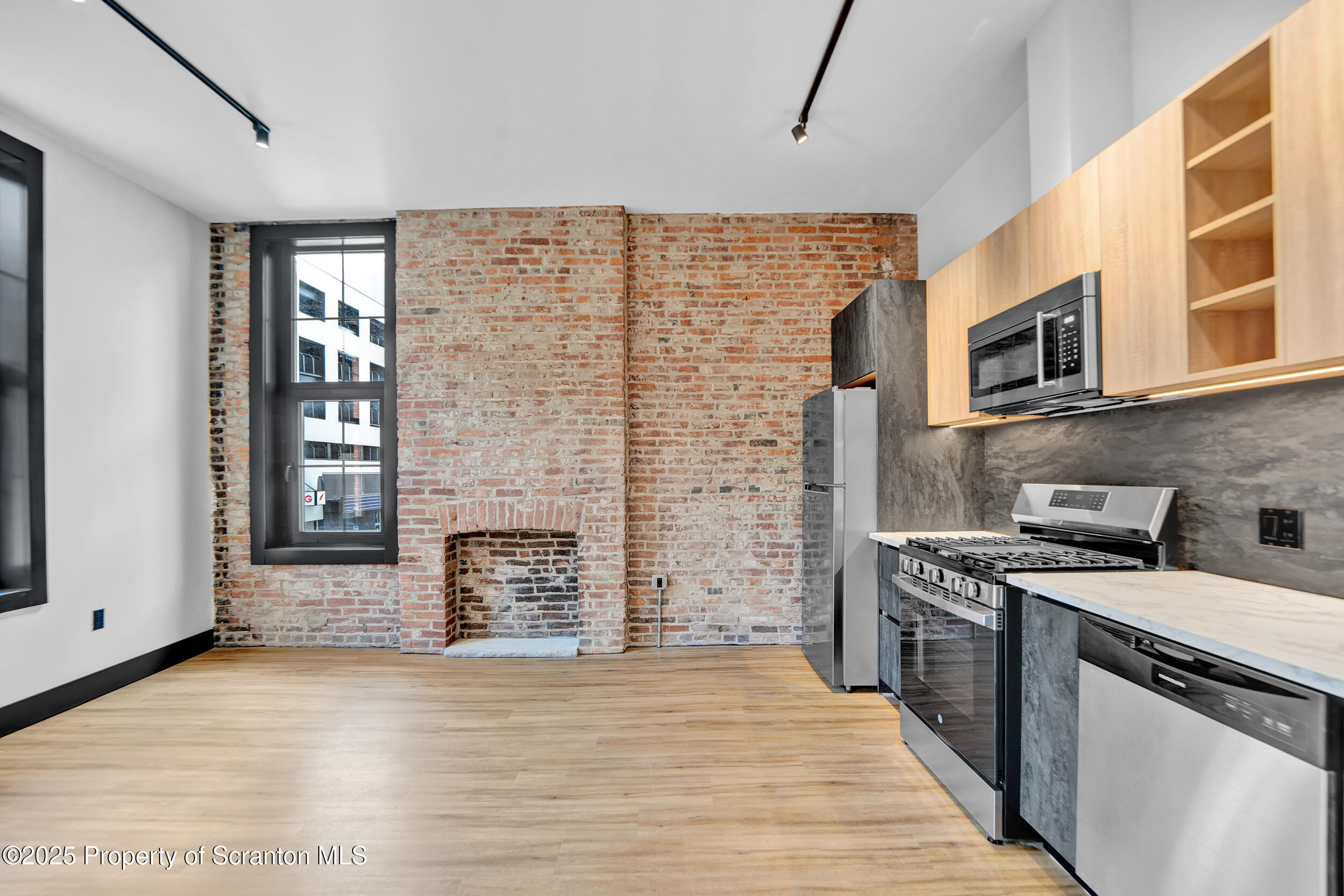 a kitchen with stainless steel appliances a stove top oven a sink and a refrigerator