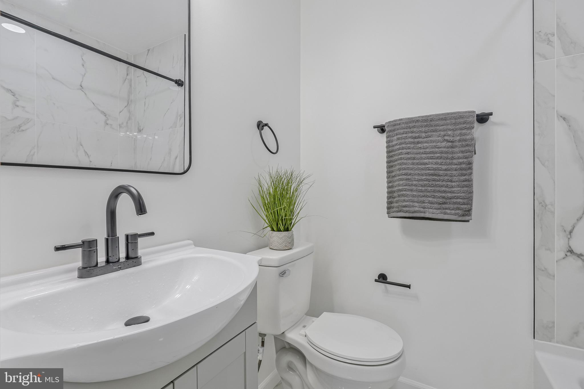 7842 Burnside Road Landover, MD 20785 - Photo 18 of 31 a bathroom with a toilet sink and mirror