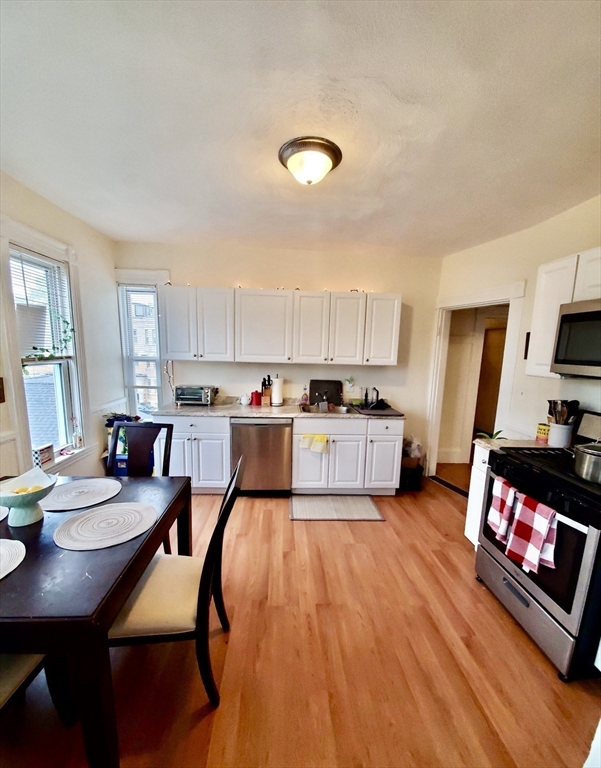 40 Forest Street, Unit 3 Boston, MA 02119 - Photo 4 of 20 a living room with stainless steel appliances kitchen island granite countertop furniture and a dining table