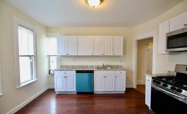 a kitchen with stainless steel appliances granite countertop a stove a sink and a microwave