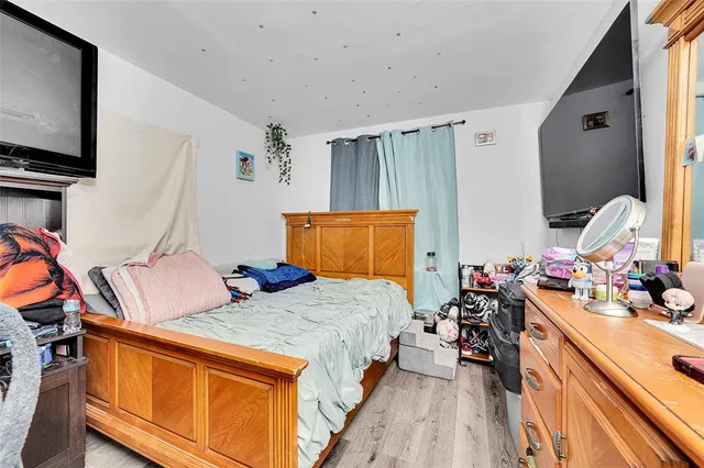 a bed room with bed and a flat tv screen on dresser