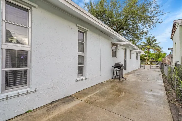 a view of house with backyard and trees in the background