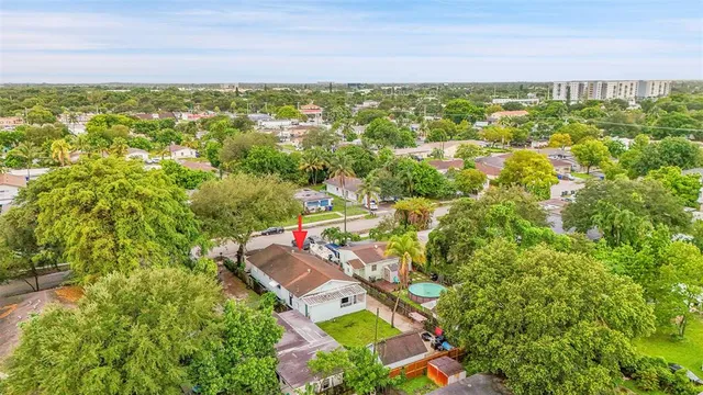 an aerial view of residential houses with outdoor space and trees