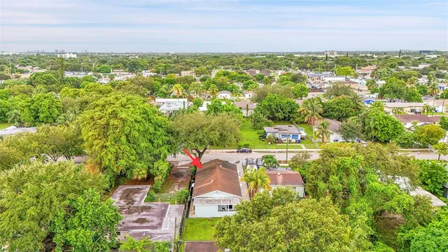 an aerial view of residential houses with outdoor space and trees