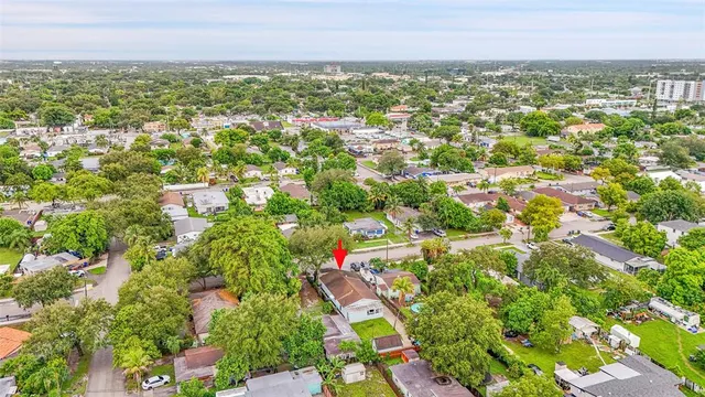 an aerial view of residential houses with outdoor space and trees