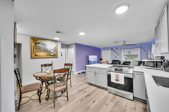 a kitchen with a stove a table and chairs in it