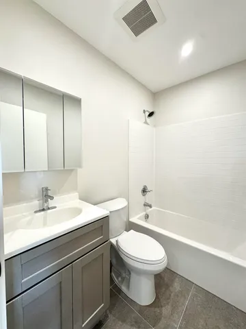 a bathroom with a toilet a sink a mirror and a bathtub