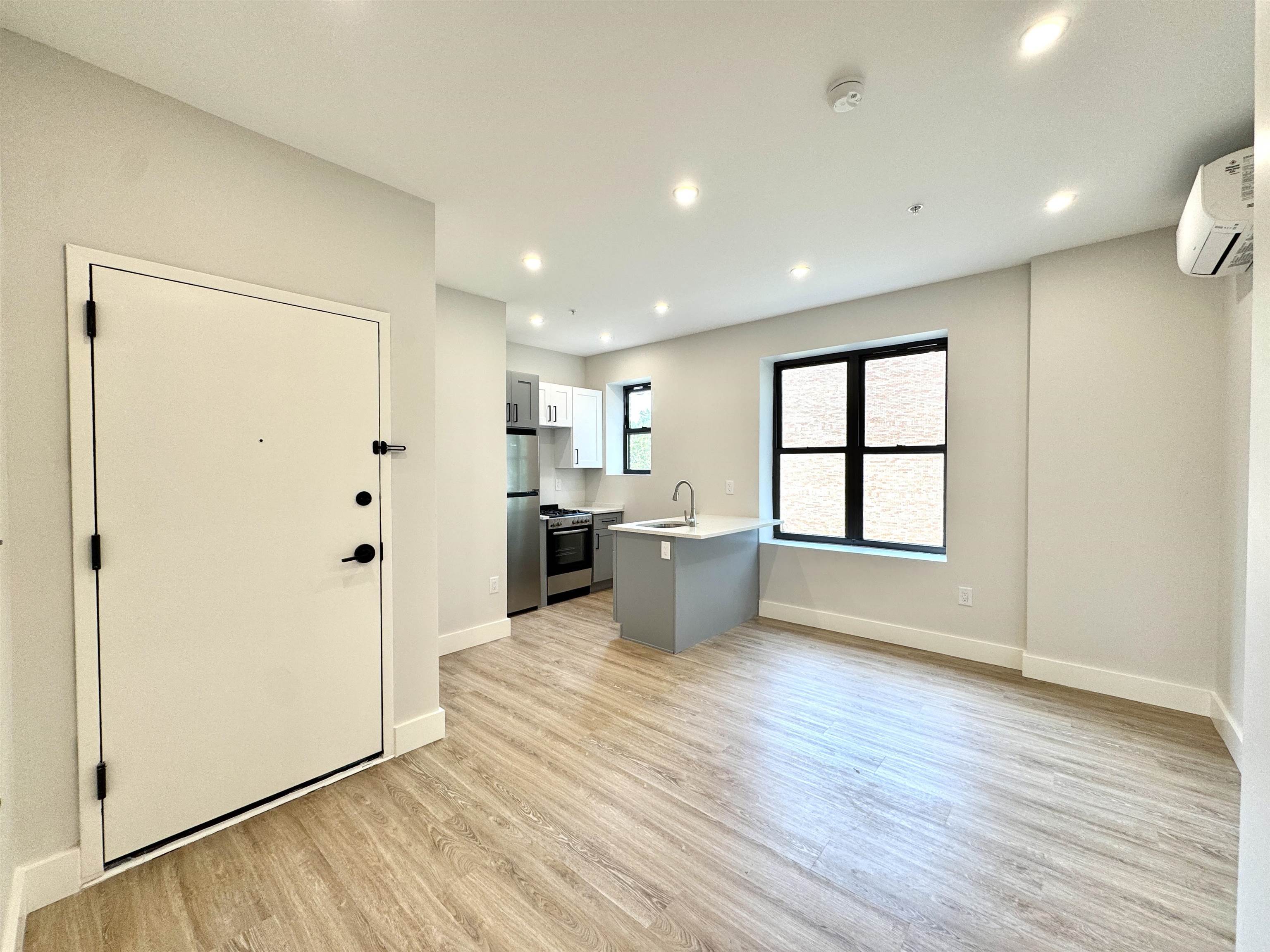103 Bostwick Avenue, Unit 3C Jersey City, NJ 07305 - Photo 9 of 11 a view of a kitchen with a refrigerator and wooden floor