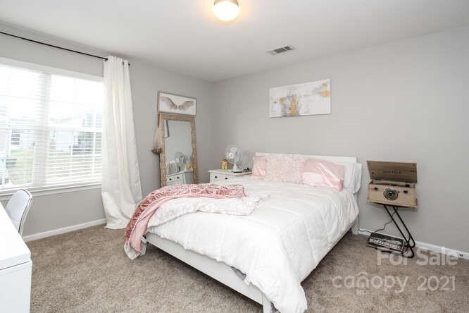 1431 River Run Road Lowell, NC 28098 - Photo 19 of 26 a bedroom with a bed a mirror and a large window