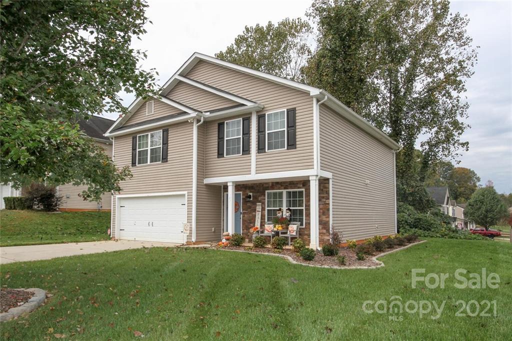 1431 River Run Road Lowell, NC 28098 - Photo 2 of 26 a view of a white house with a big yard potted plants and large tree