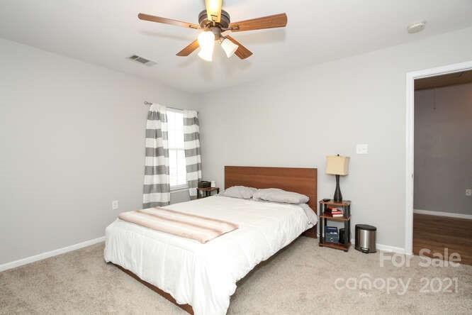 1431 River Run Road Lowell, NC 28098 - Photo 22 of 26 a bedroom with a large bed and a chandelier fan