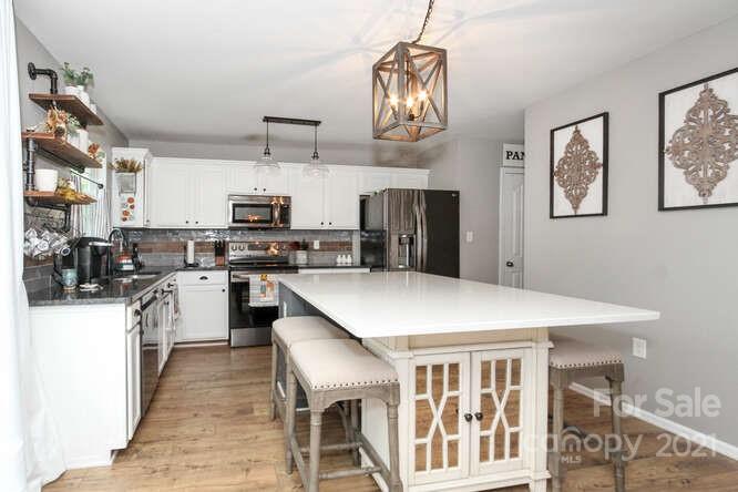 1431 River Run Road Lowell, NC 28098 - Photo 26 of 26 a kitchen with cabinets and wooden floor