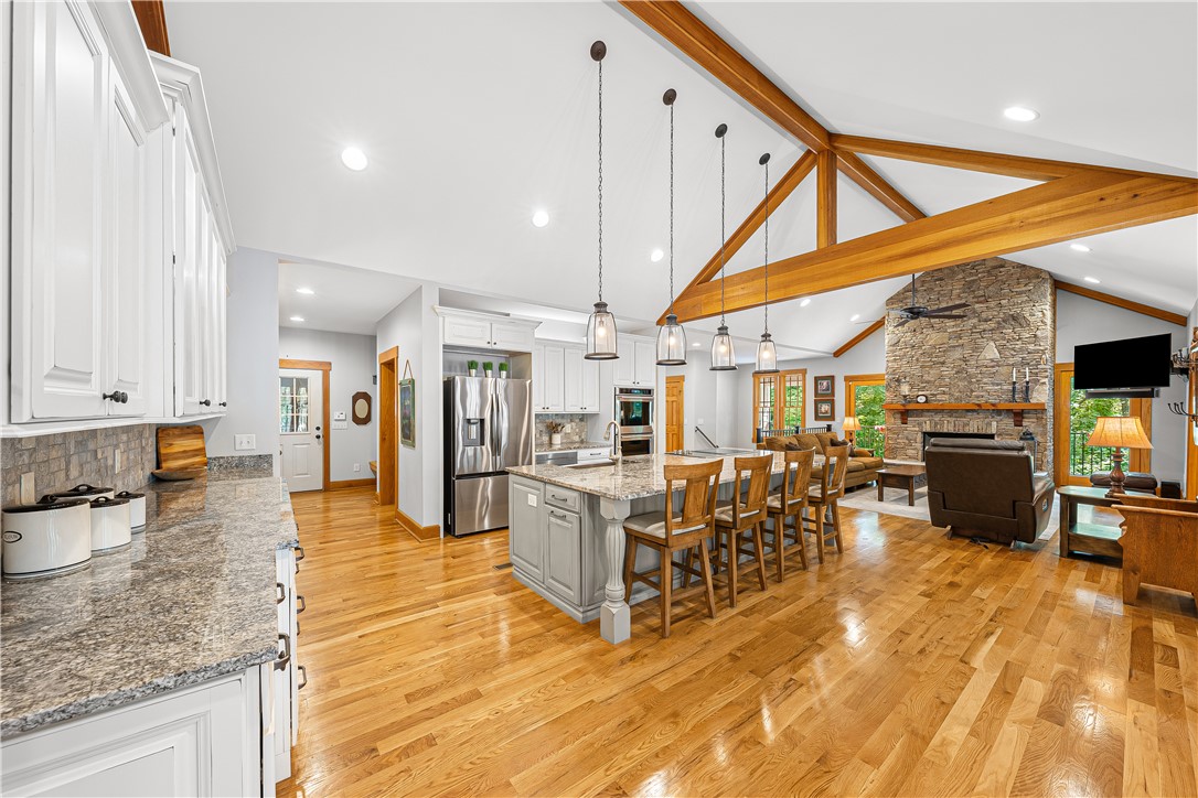 285 Bertha Allen Road Westminster, SC 29693 - Photo 50 of 50 An open concept floorplan with wood flooring flows between the well-appointed kitchen and a comfortable great room with a stone fireplace.