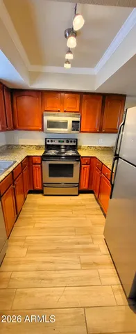 a kitchen with stainless steel appliances wooden cabinets and a stove top oven