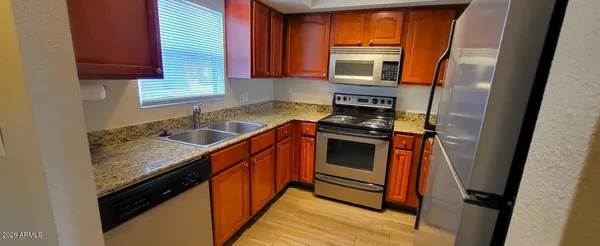 a kitchen with granite countertop a sink stove and cabinets