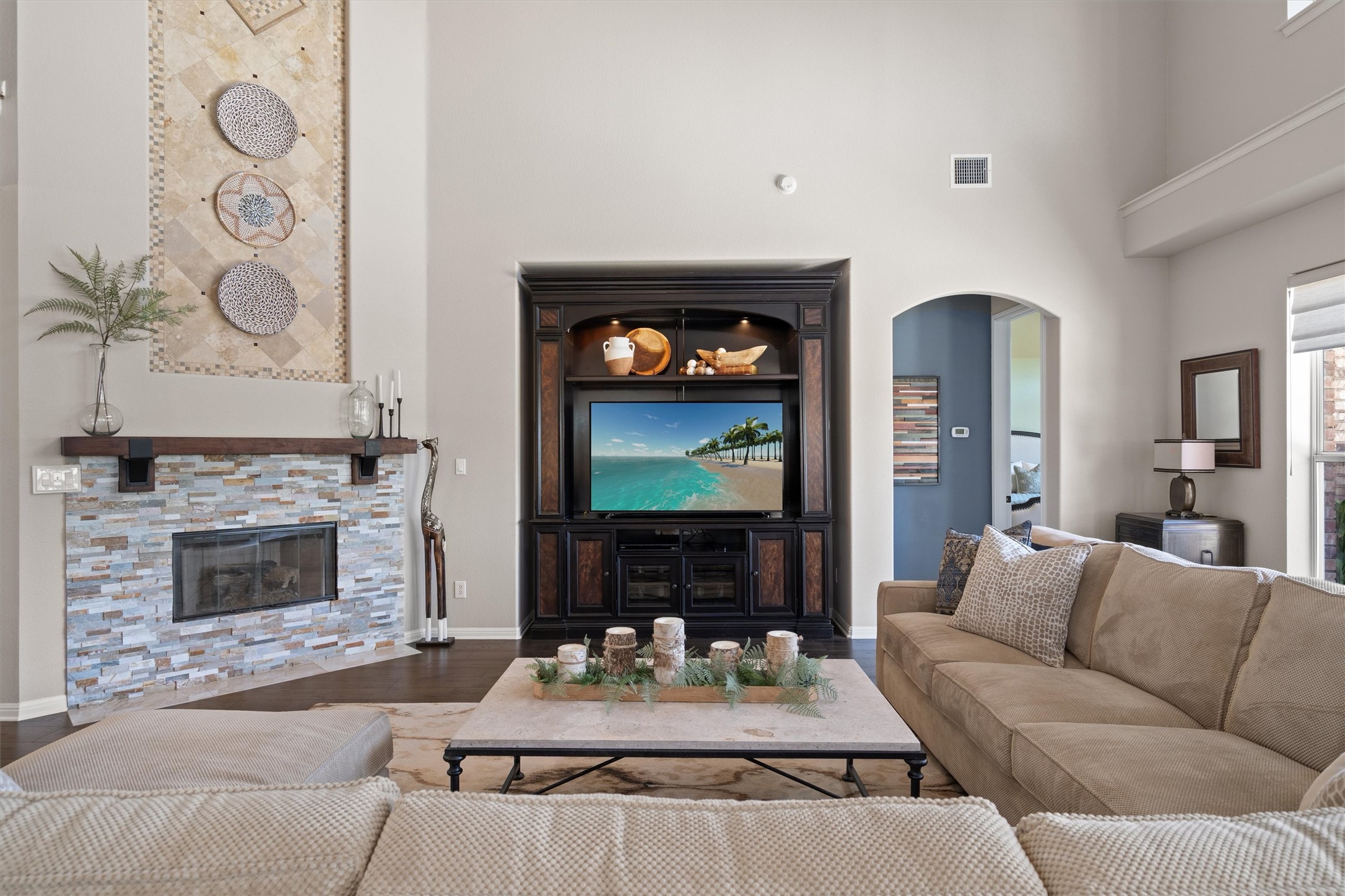 3105 Castellano Way Cedar Park, TX 78613 - Photo 10 of 40 Large, open concept family room with a striking fireplace focal point. The primary bedroom is conveniently located just off the main living area, offering a thoughtful balance of openness and privacy.