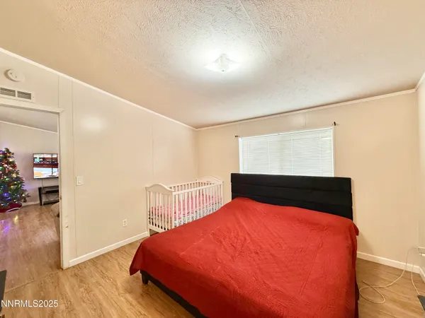 a bedroom with a bed and wooden floor