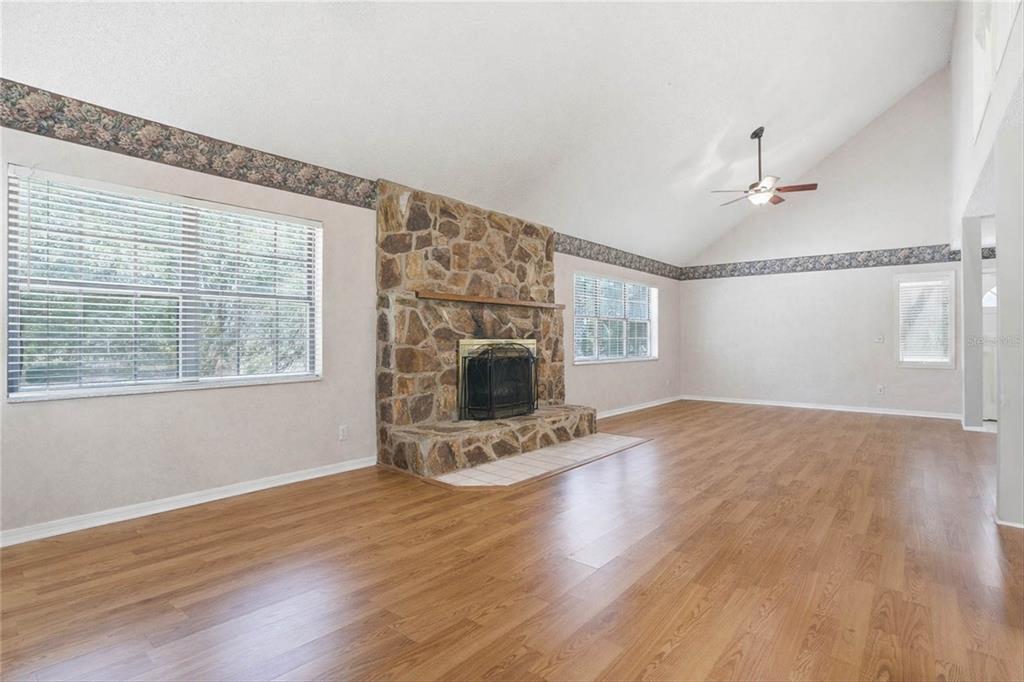 596 Highway 20 Palatka, FL 32177 - Photo 34 of 49 an empty room with wooden floor fireplace and windows