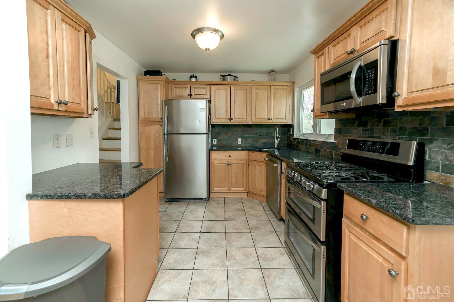 26 Phillips Road Edison, NJ 08817 - Photo 13 of 27 a kitchen with granite countertop a refrigerator a stove top oven and sink