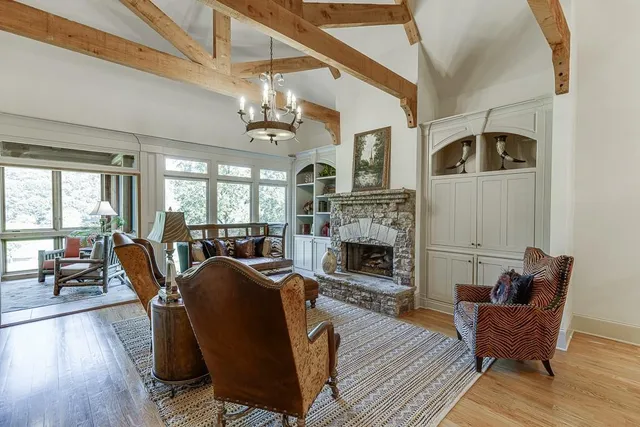 a living room with furniture a chandelier and a fireplace