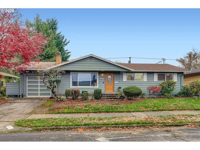 a front view of a house with a yard and potted plants