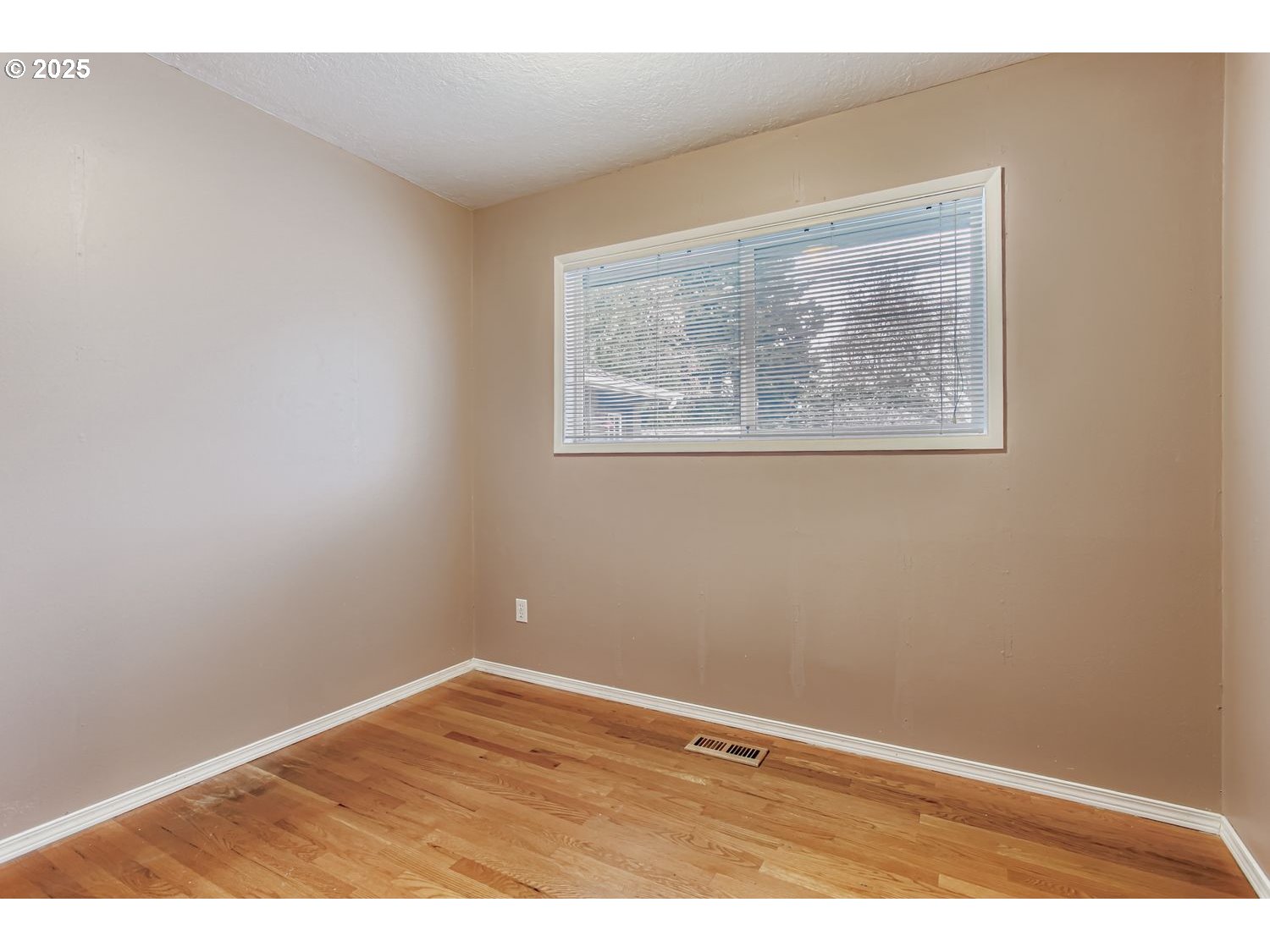 10832 Southeast Stephens Street Portland, OR 97216 - Photo 19 of 36 a view of an empty room with wooden floor and a window
