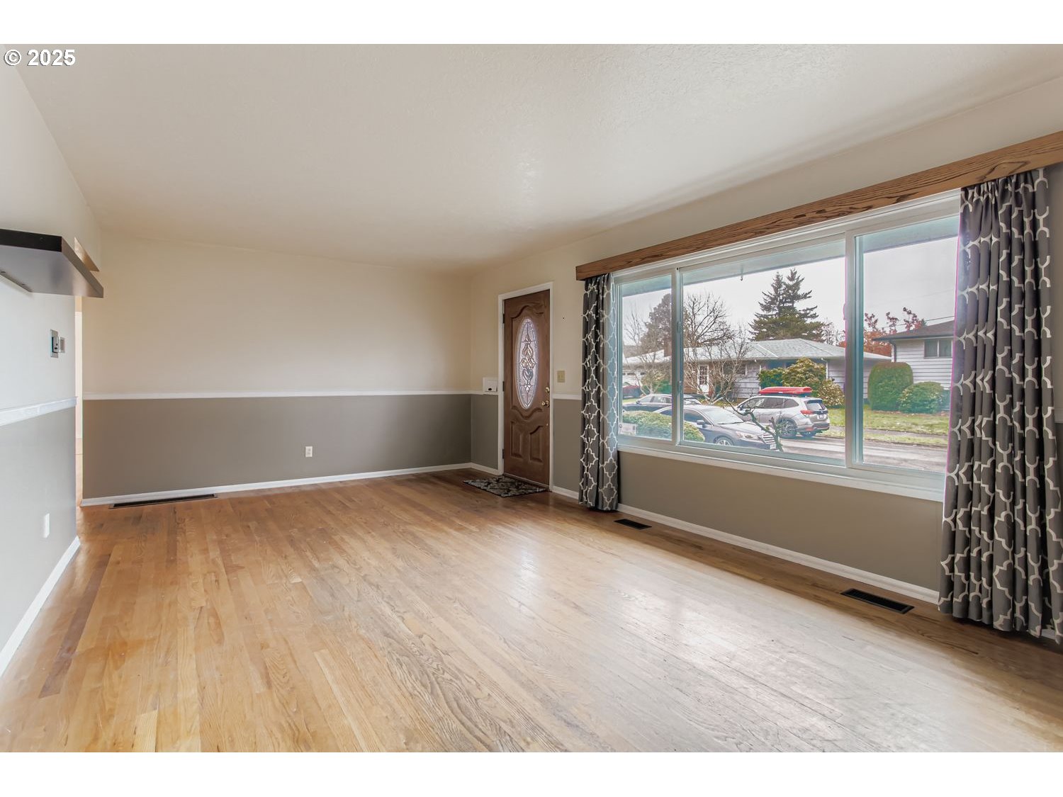 10832 Southeast Stephens Street Portland, OR 97216 - Photo 4 of 36 an empty room with wooden floor and windows