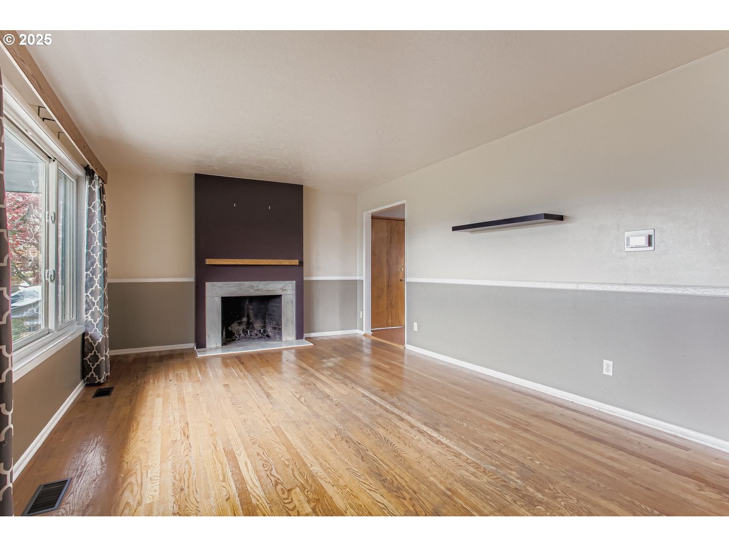 10832 Southeast Stephens Street Portland, OR 97216 - Photo 6 of 36 a view of an empty room with wooden floor and a window
