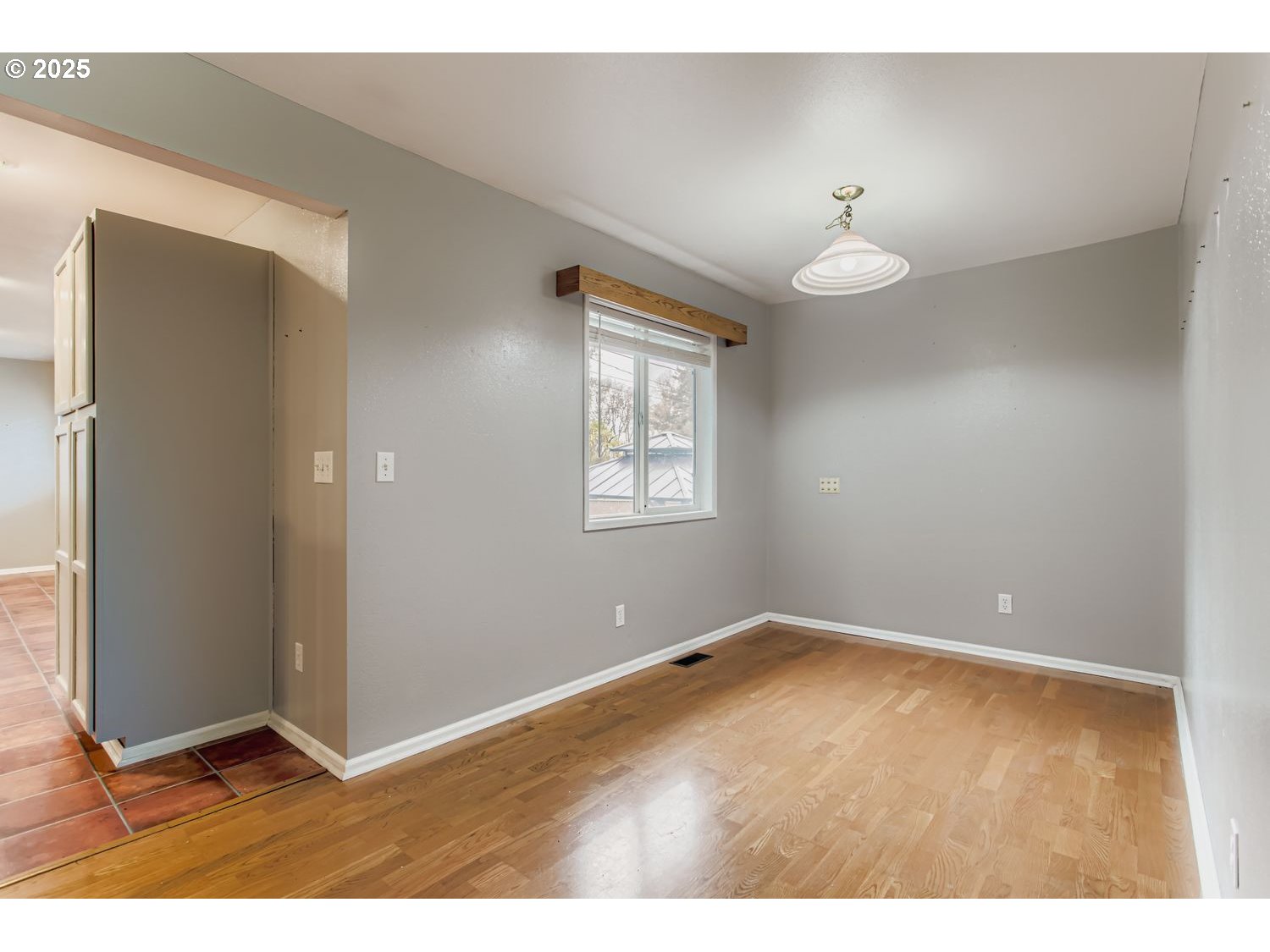 10832 Southeast Stephens Street Portland, OR 97216 - Photo 7 of 36 a view of an empty room with wooden floor and a window