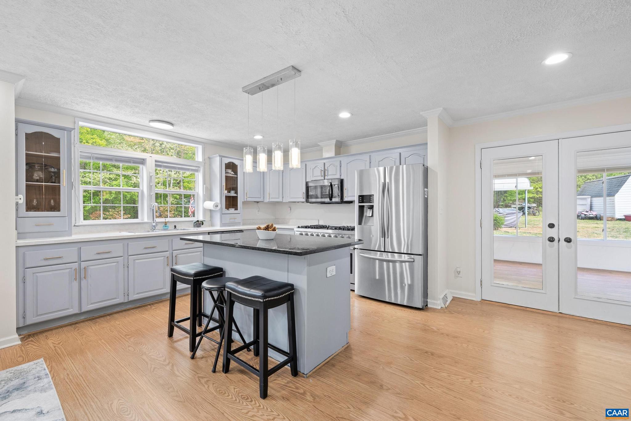 3151 Waldrop Church Road Louisa, VA 23093 - Photo 15 of 42 a kitchen with kitchen island granite countertop a stove a sink a refrigerator and white cabinets with wooden floor
