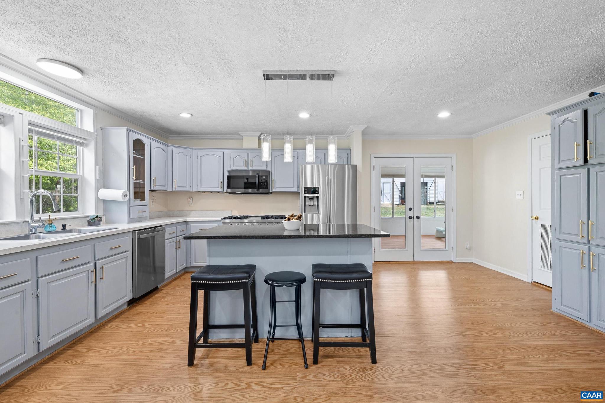 3151 Waldrop Church Road Louisa, VA 23093 - Photo 17 of 42 a kitchen with stainless steel appliances granite countertop counter space a sink cabinets and a refrigerator