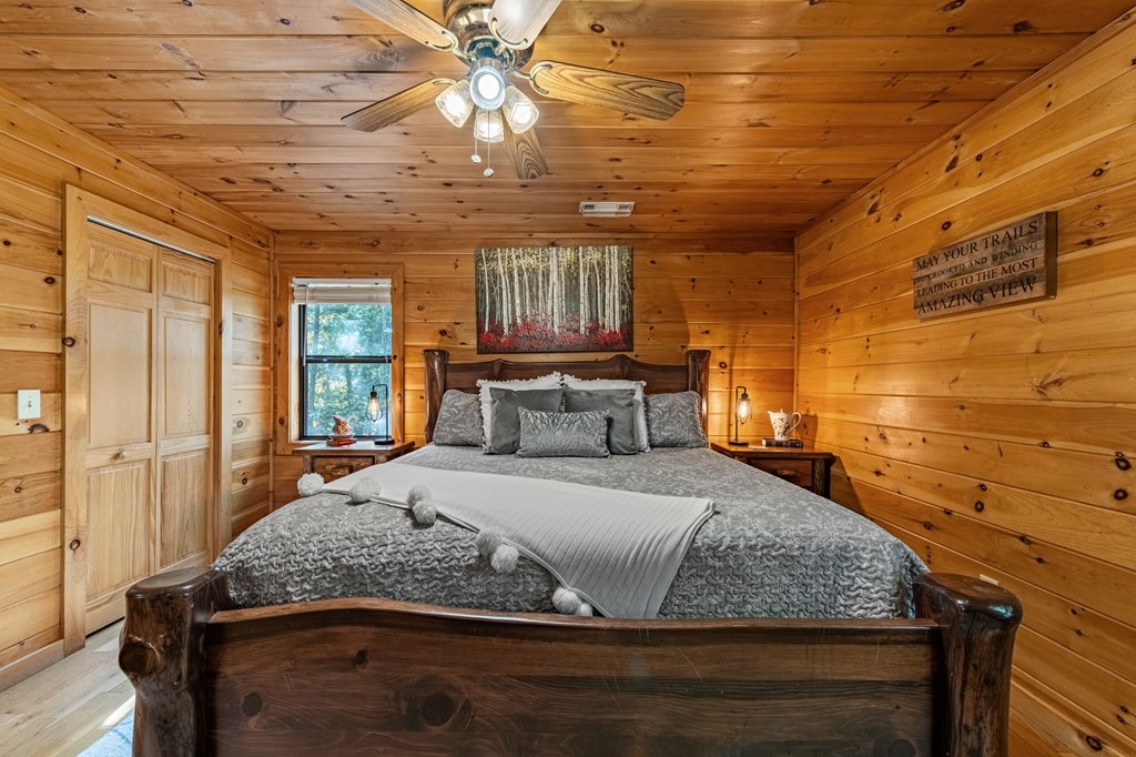 196 Ethan Wilson Way Morganton, GA 30560 - Photo 43 of 66 a bedroom with a large bed and a chandelier