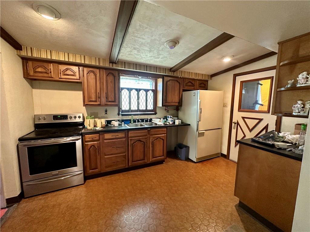 741 Frederick Street McKees Rocks, PA 15136 - Photo 7 of 18 a kitchen with a refrigerator a stove a sink dishwasher and wooden cabinets