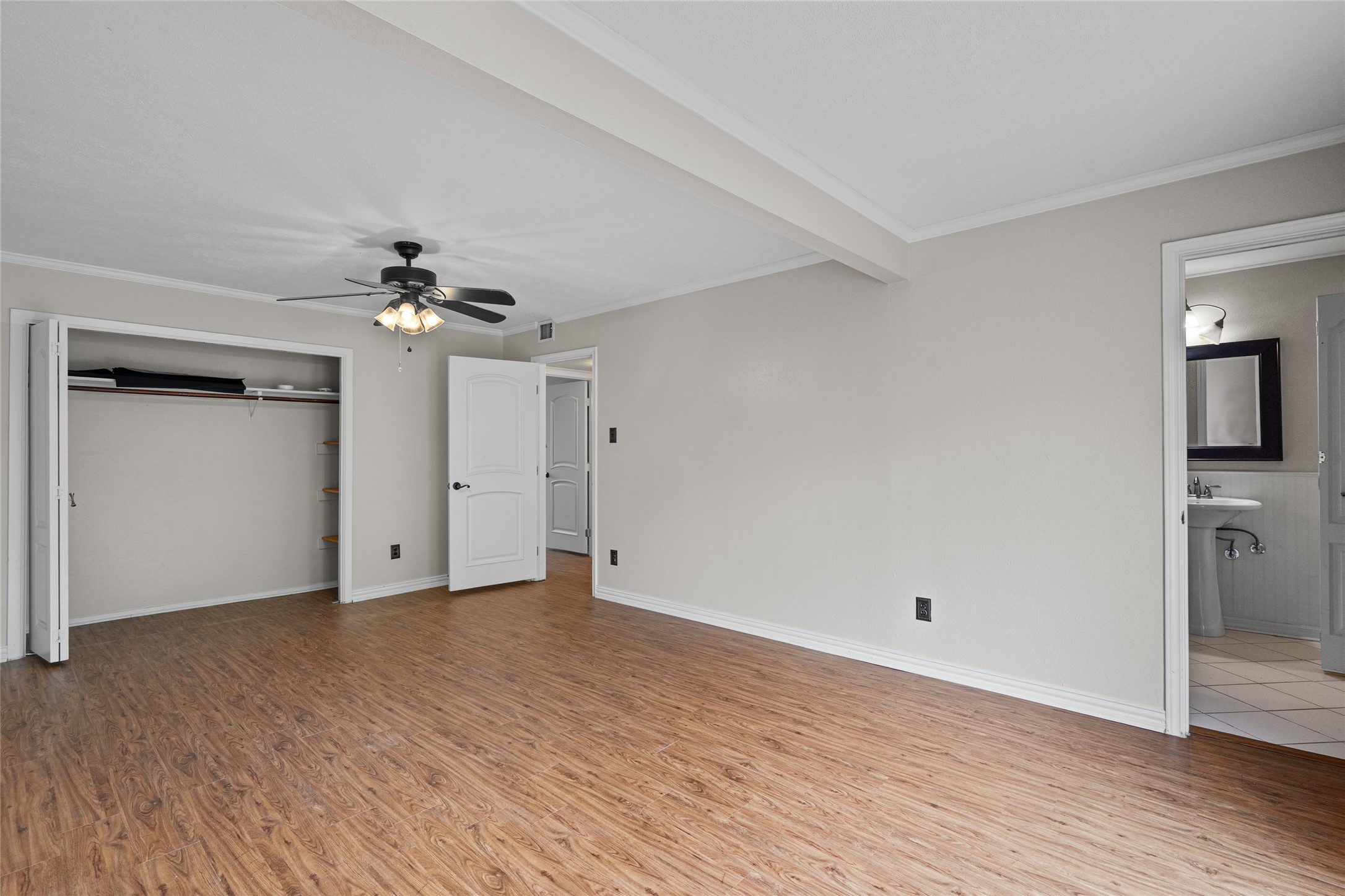 806 Castle Ridge Road, Unit C Austin, TX 78746 - Photo 16 of 28 A spacious bedroom features warm wood flooring and a refreshing ceiling fan for comfortable living.