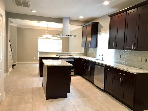 a kitchen with stainless steel appliances granite countertop wooden cabinets a sink and a counter top