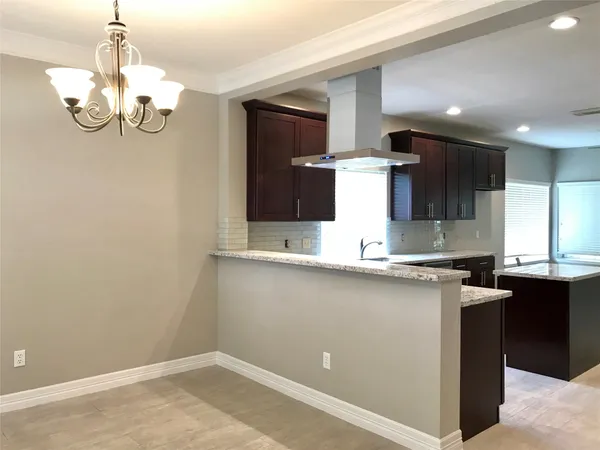 a view of a kitchen with a sink and chandelier